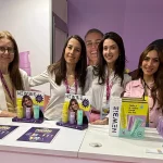 Integrantes de New3ie exponiendo producto en su stand.