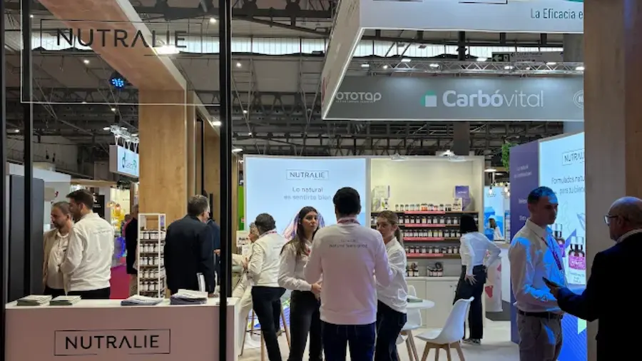 Stand de Nutralie en Infarma con gente manteniendo conversas en su interior